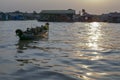 Woman in boat through floating fishing village of Tonle Sap River in Cambodia