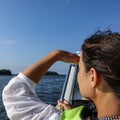 Woman in a boat looking out over the ocean and shades her eyes Royalty Free Stock Photo