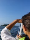 Woman in a boat looking out over the ocean and shades her eyes Royalty Free Stock Photo