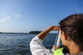 Woman in a boat looking out over the ocean and shades her eyes Royalty Free Stock Photo