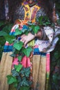 Woman in boho style silk dress in garden wrapped in green ivy lower body summer