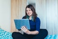 Woman bonding with friends during quarantine indoors. Female using tablet