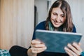 Woman bonding with friends during quarantine indoors. Female using tablet