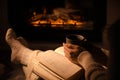 Woman with book and cup near fireplace indoors, closeup. Cozy atmosphere Royalty Free Stock Photo