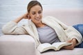 Woman, book and happy on sofa with reading, relax or learning for education or break in living room of home. Person