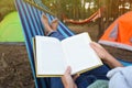 Woman with book resting in comfortable hammock outdoors, closeup Royalty Free Stock Photo