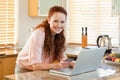 Woman booking flight online in the kitchen