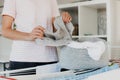 Woman hanging clean wet clothes laundry on drying rack at home laundry room Royalty Free Stock Photo