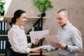 Woman boss shakes hands with a subordinate.