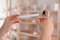 Woman with bottle of perfume and blotter indoors