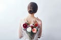 Woman with a bouquet of artificial flowers behind her. The girl in a light transparent dress with an open back and flowers. Art Royalty Free Stock Photo