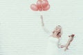 Woman with Bouquet and Baloons Standing in Room. Royalty Free Stock Photo