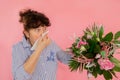 Woman bouquet of flowers hands take hankie sneezes closed eyes concept allergy illness discomfort pink background