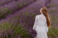 Woman with Bouquet of Flowers Walking on Lavender Field Royalty Free Stock Photo