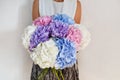 Woman with bouquet of hydrangeas. Beautiful fresh delicate flowers for holiday. Woman with beautiful flowers in her hands