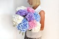 Woman with bouquet of hydrangeas. Beautiful fresh delicate flowers for holiday. Woman with beautiful flowers in her hands