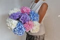 Woman with bouquet of hydrangeas. Beautiful fresh delicate flowers for holiday. Woman with beautiful flowers in her hands