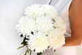 Woman with bouquet of white chrysanthemums. Beautiful fresh white flowers for holiday. Woman holding beautiful white flowers