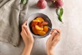 Woman with bowl full of sliced peaches at light table Royalty Free Stock Photo