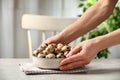 Woman with bowl of quail eggs at table indoors, closeup Royalty Free Stock Photo