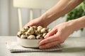 Woman with bowl of quail eggs at table indoors, closeup Royalty Free Stock Photo