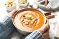 Woman with bowl of tasty sweet potato soup at table Royalty Free Stock Photo