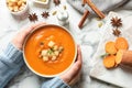 Woman with bowl of tasty sweet potato soup at table Royalty Free Stock Photo