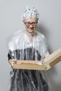 Woman with a box of pizza in the process of dyeing her hair