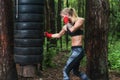 Woman boxer doing uppercut kick working out outdoors. Royalty Free Stock Photo