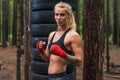 Woman boxer professional fighter posing in boxing stance, working out outdoors Royalty Free Stock Photo