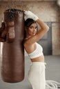 Woman boxer training with a punching bag in gym. Boxing girl wearing hand wrap