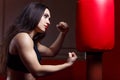 Woman boxing, hitting a punching dummy