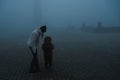 woman with a boy child on a foggy square in the city on an autumn morning in fog mist