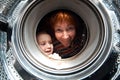 Woman and boy peer into get washer