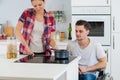 Woman and boyfriend on wheelchair cooking at home Royalty Free Stock Photo