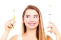 Woman with braces holding electric and traditional toothbrush