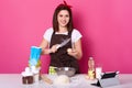 Woman brakes egg with knife, puts it into plate of flour, needs some more dough for preparing hot cross buns, ready for kneading Royalty Free Stock Photo