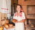 Woman with bread near traditional stove