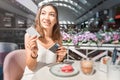 Woman after breakfast in a cafe pays with a credit card. Royalty Free Stock Photo