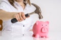 Woman is breaking piggy money bank with hammer to take her savings Royalty Free Stock Photo