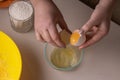 A woman breaks an egg into a glass dish to make a pie Royalty Free Stock Photo