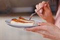 Woman breaks spoonful of slice of cheesecake close Royalty Free Stock Photo