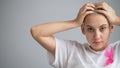 Woman with breast cancer holding her head on white background. Royalty Free Stock Photo