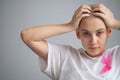 Woman with breast cancer holding her head on white background. Royalty Free Stock Photo