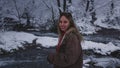 Woman breathes in chilly air strolling along forest path captivated by winter beauty