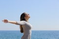 Woman breathing deep fresh air and raising arms