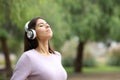 Woman breathing with headphone meditating in a park Royalty Free Stock Photo