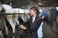 Woman breeder collecting goat milk
