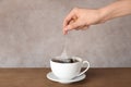 Woman brewing tea with bag in cup on table Royalty Free Stock Photo