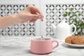 Woman brewing tea with bag in cup on table Royalty Free Stock Photo